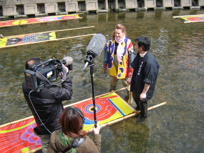 Judit Kawaguchi and master koinobori artist washing the freshly painted koinobori in the Gojo river 